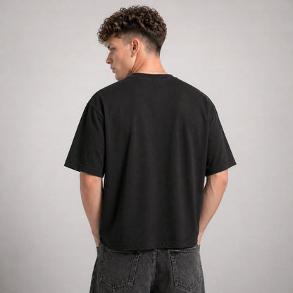 Person wearing a black t-shirt against a gray background