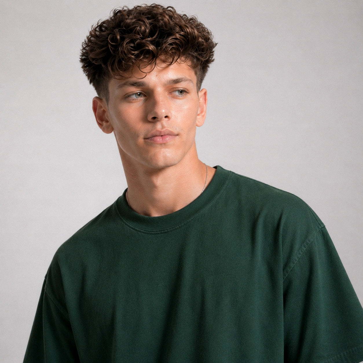 Man wearing a dark green sweatshirt against a plain background