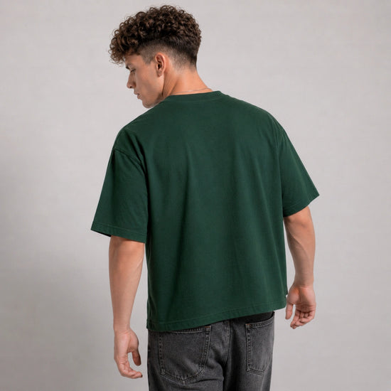 Person wearing a green t-shirt on a plain background