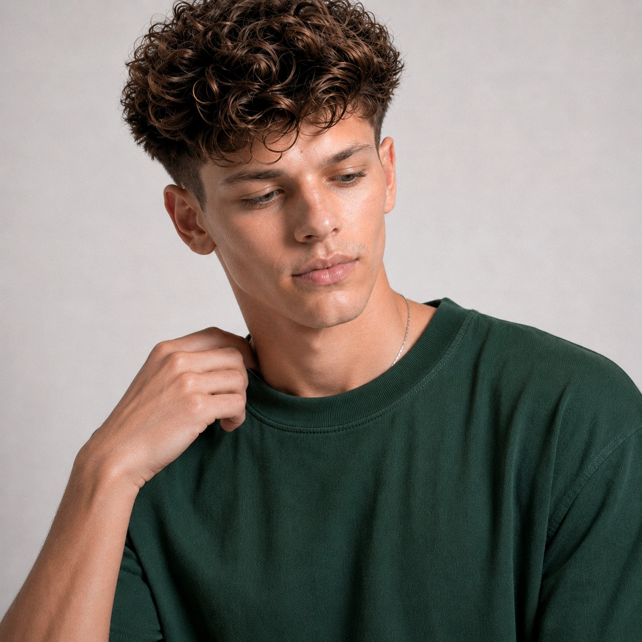 Man wearing a green shirt against a gray background