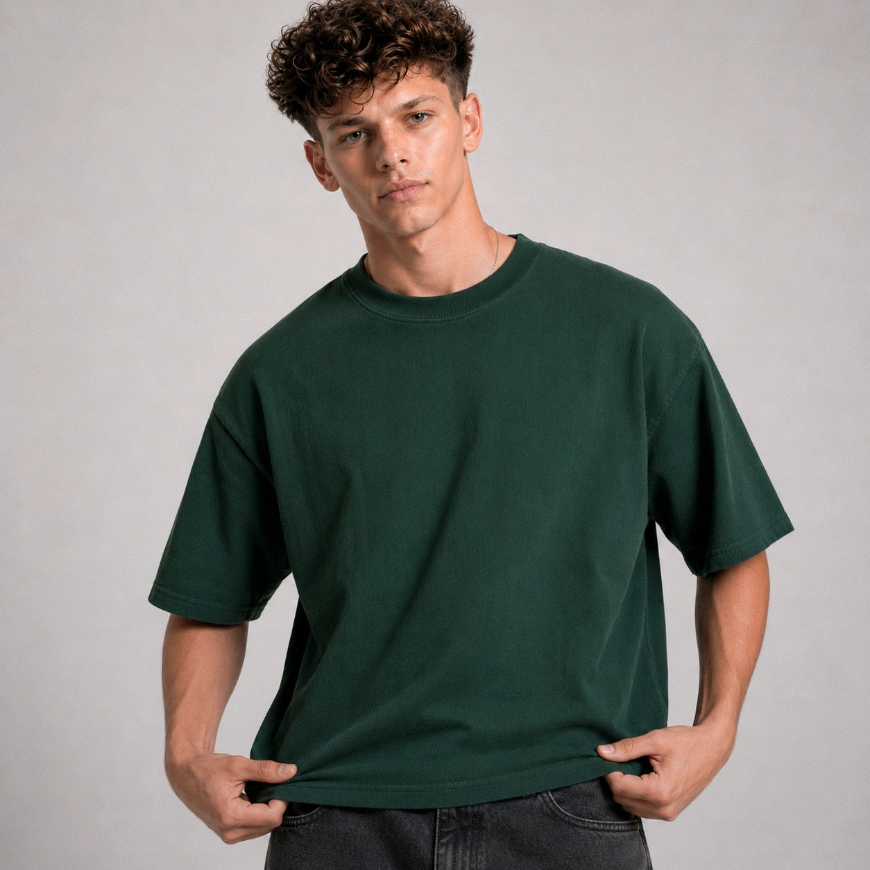 Man wearing a dark green t-shirt against a gray background