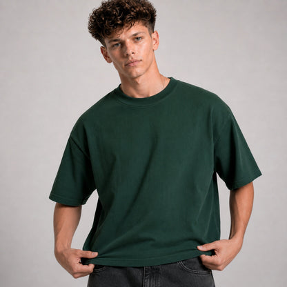 Man wearing a dark green t-shirt against a gray background