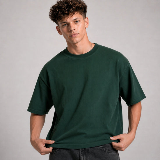 Man wearing a dark green t-shirt against a gray background