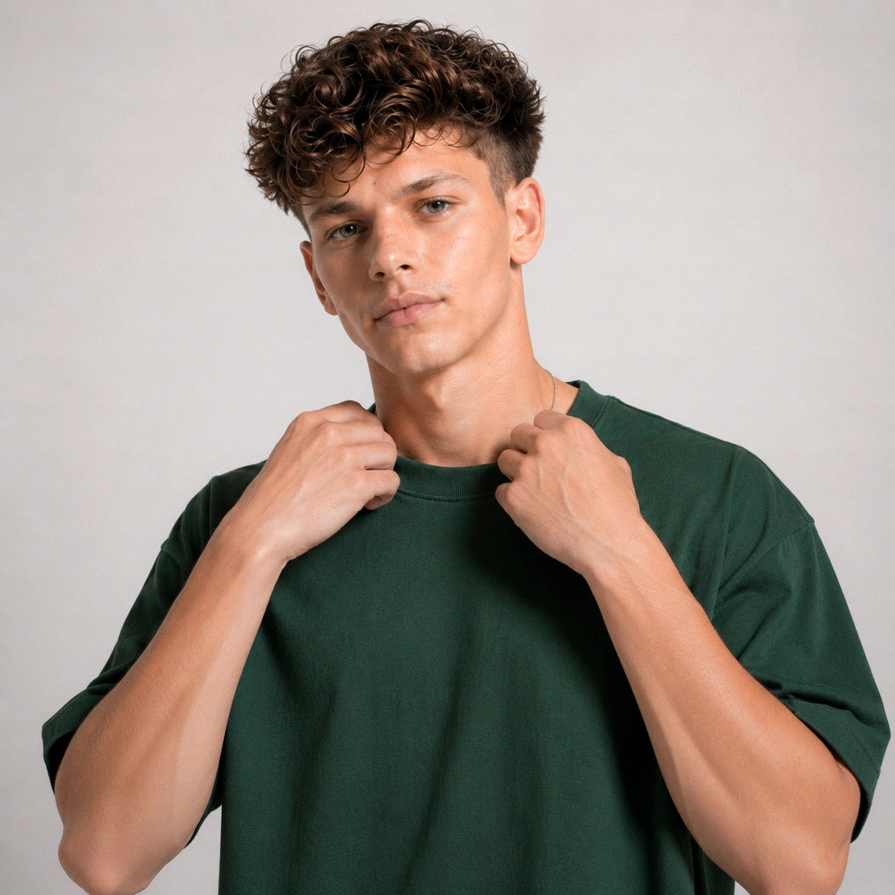 Man wearing a green t-shirt against a plain background
