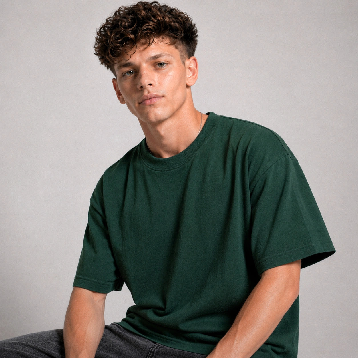 Man wearing a green t-shirt against a plain background