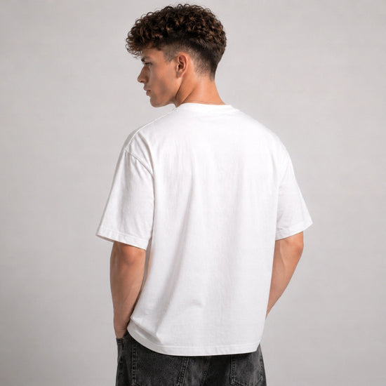 Person wearing a plain white t-shirt on a gray background