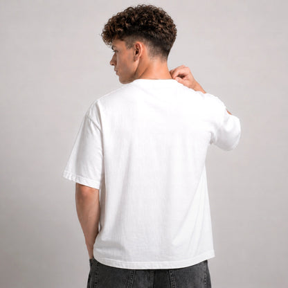 Person wearing a plain white t-shirt against a gray background