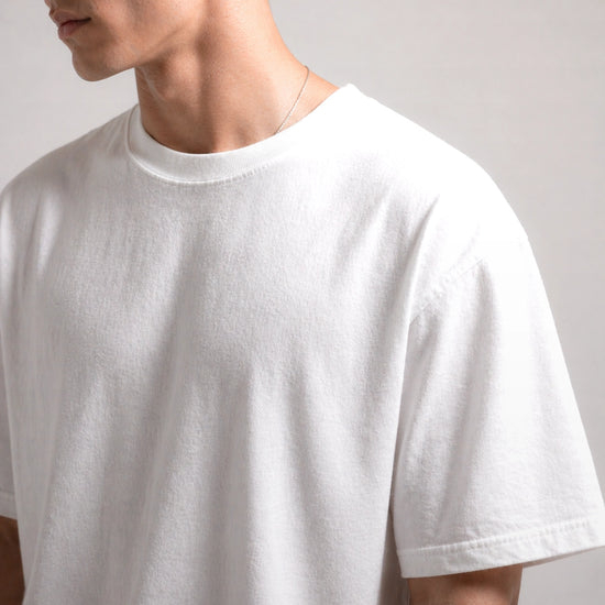 White t-shirt worn by a person on a plain background