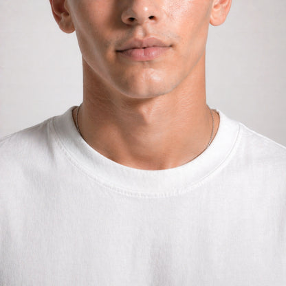 Close-up of a person wearing a plain white t-shirt against a neutral background