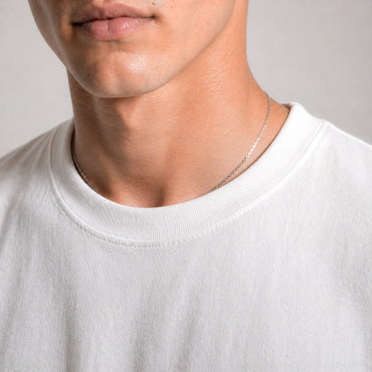 Close-up of a person wearing a white shirt with a neutral background