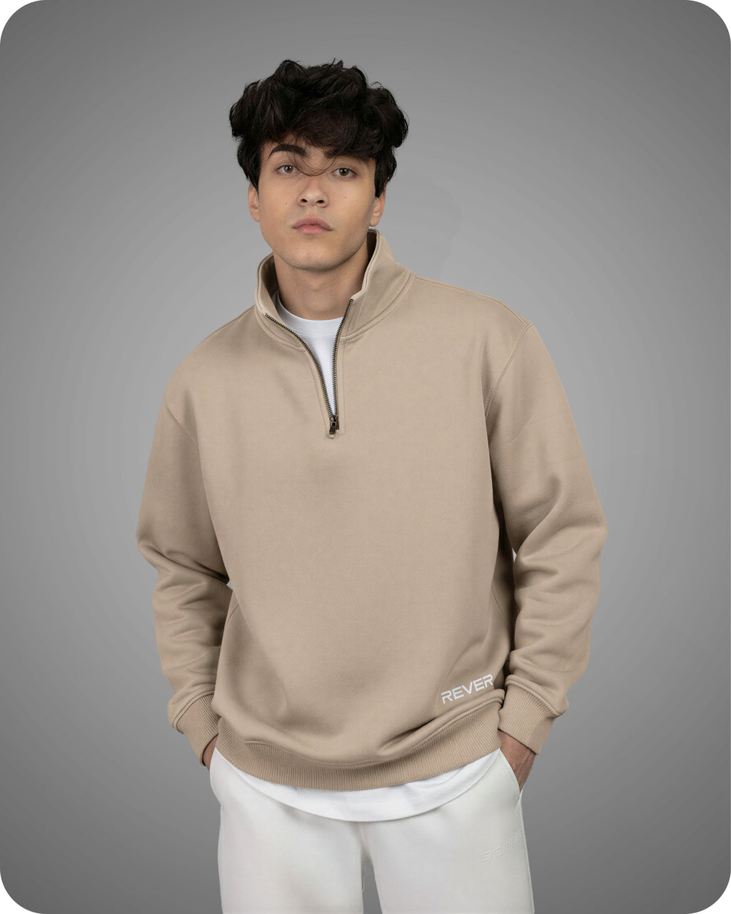 Man wearing a beige pullover with a zipper on a gray background