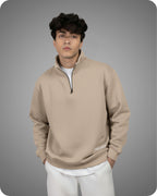 Man wearing a beige pullover with a zipper on a gray background