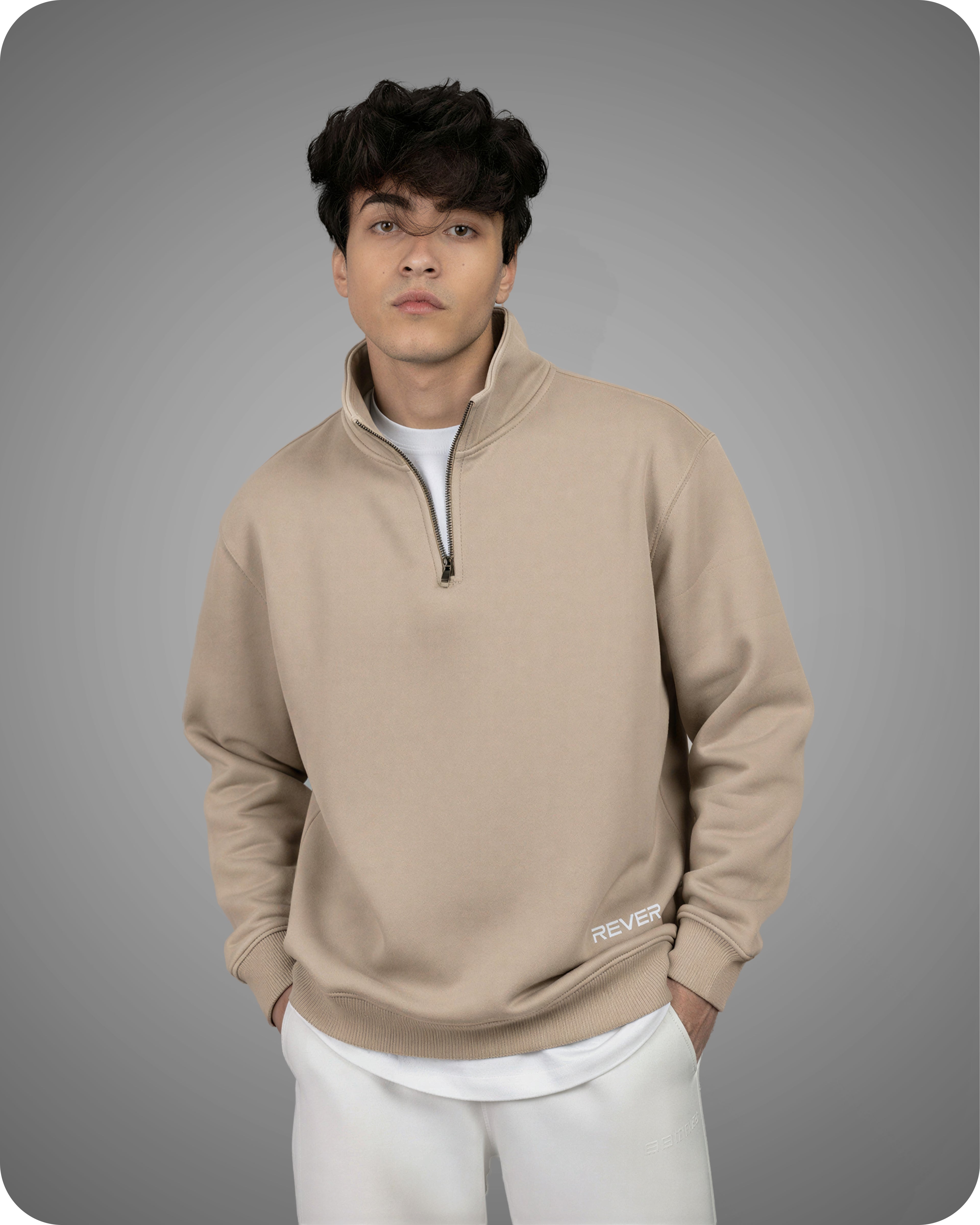 Man wearing a beige pullover with a zipper on a gray background