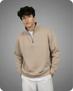 Man wearing a beige pullover with a zipper on a gray background