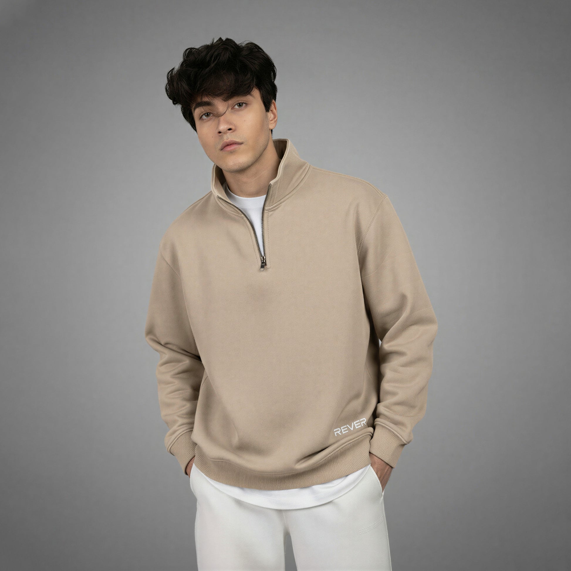 Man wearing a beige pullover with a zipper on a gray background
