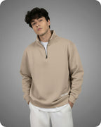 Man wearing a beige pullover with a zipper on a gray background