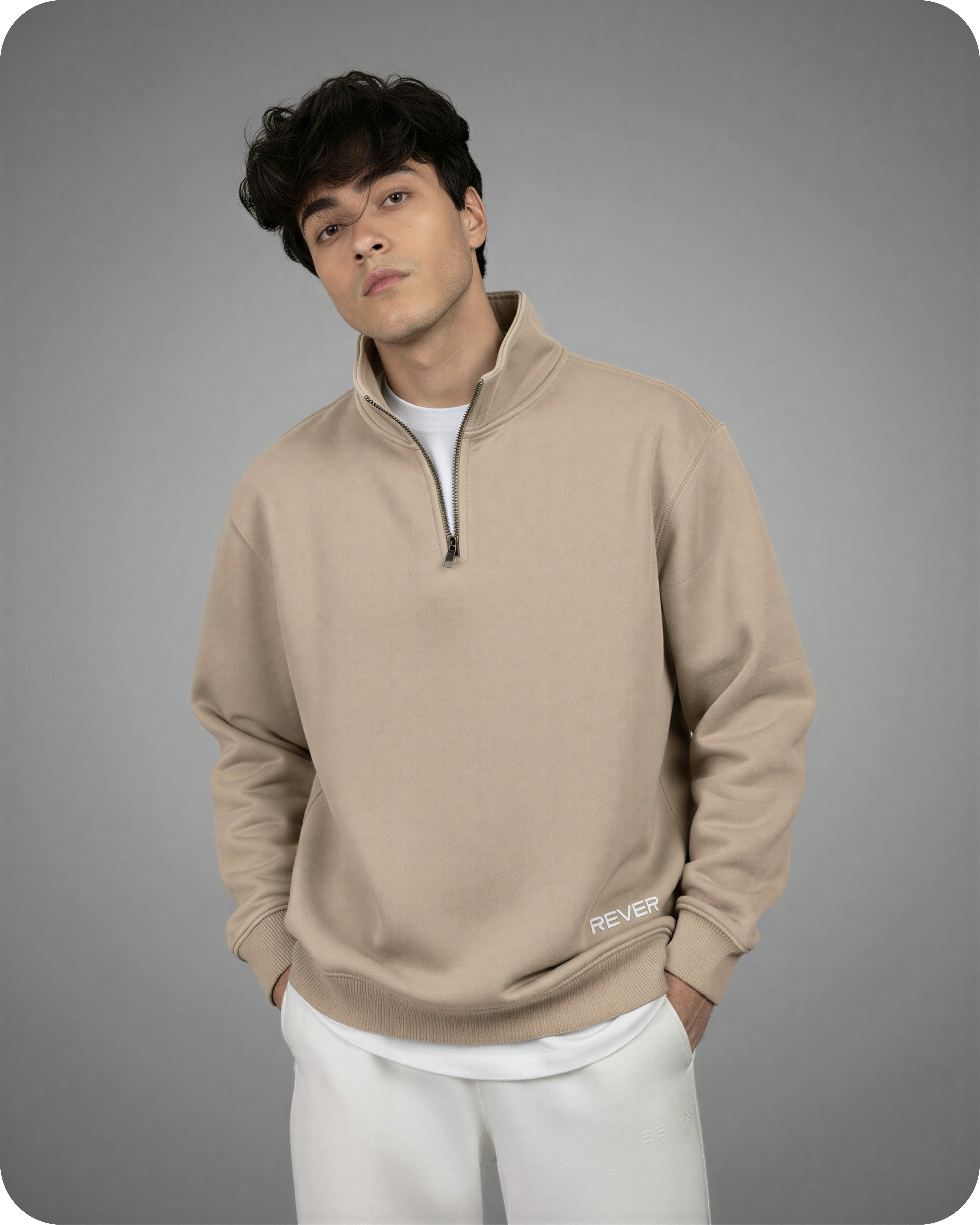 Man wearing a beige pullover with a zipper on a gray background