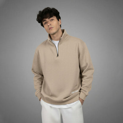 Man wearing a beige pullover with a zipper on a gray background