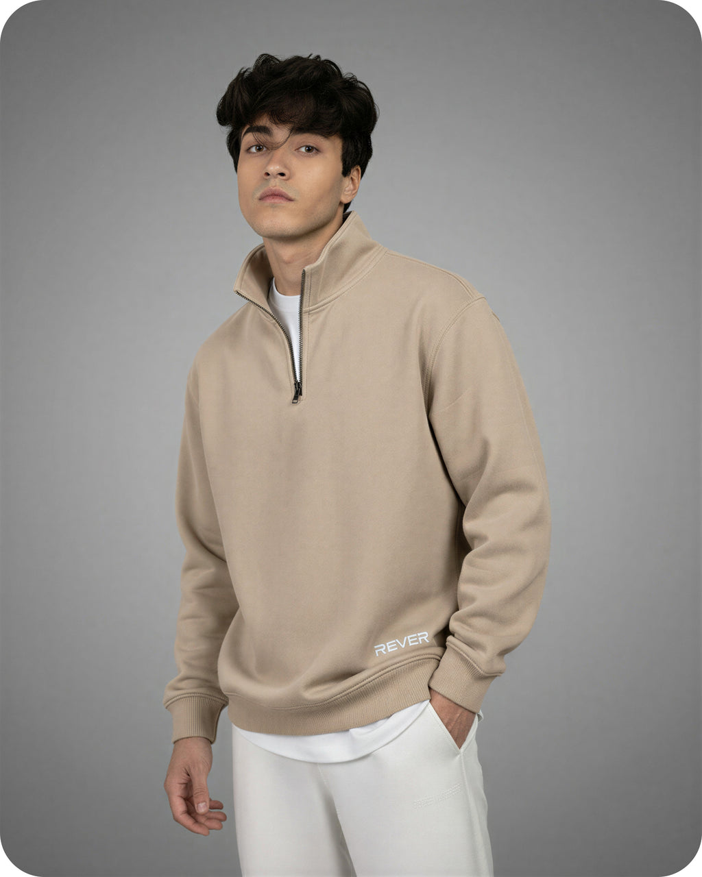 Man wearing a beige pullover with 'Rever' logo on a gray background