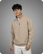 Man wearing a beige pullover with a gray background