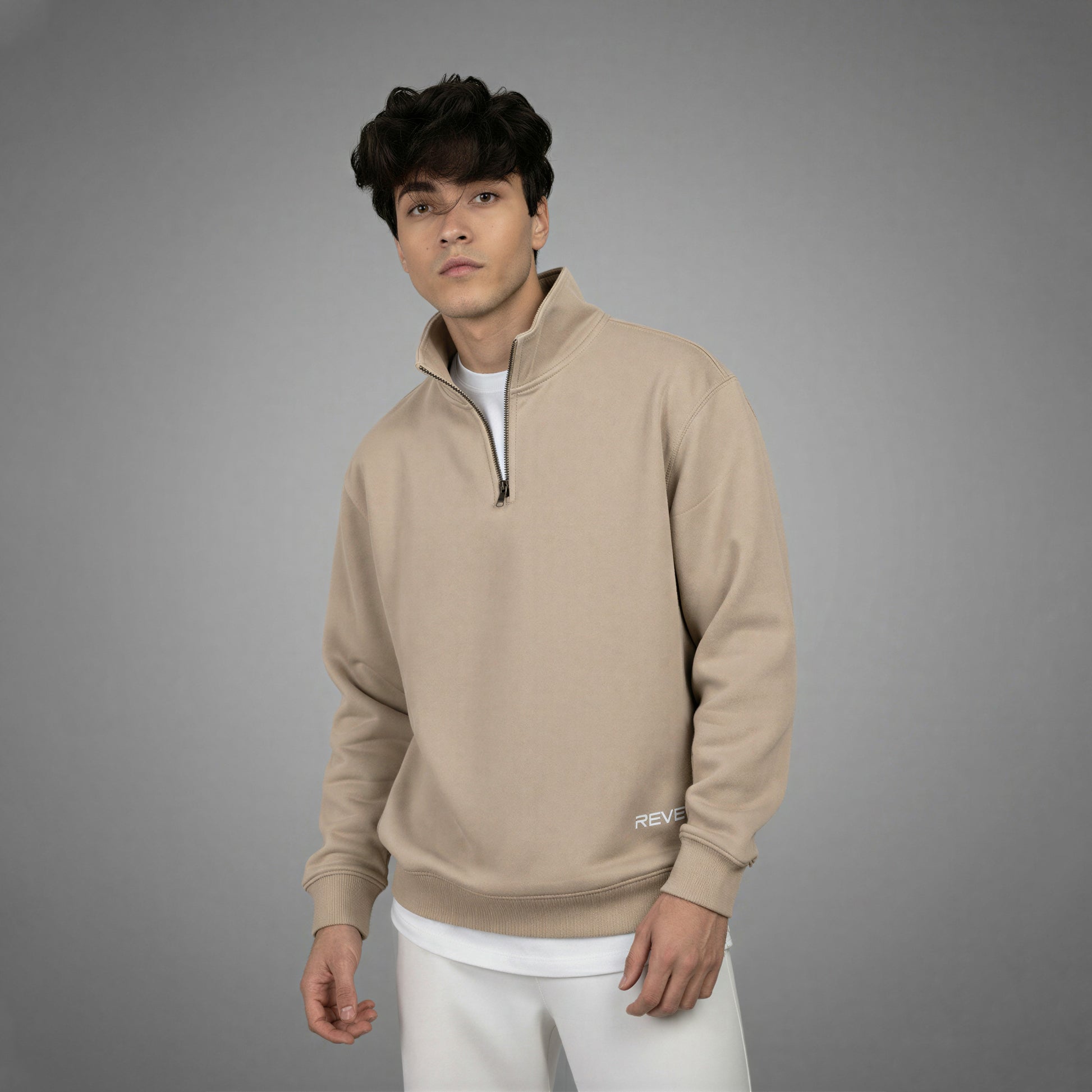 Man wearing a beige pullover with a gray background