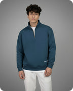 Man wearing a blue pullover with a gray background