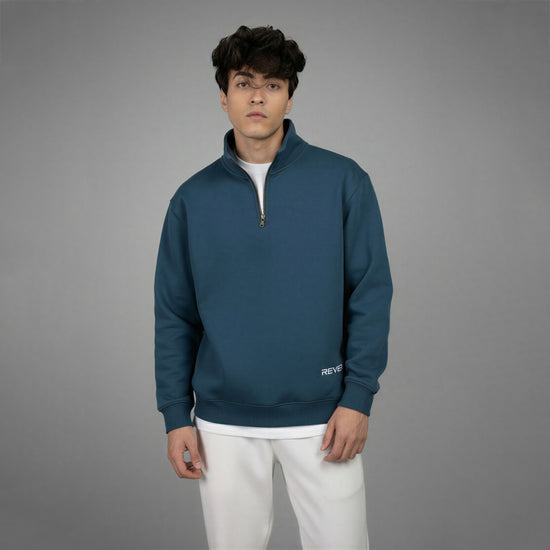 Man wearing a blue pullover with a gray background