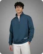 Man wearing a blue pullover with 'REVER' branding on a gray background