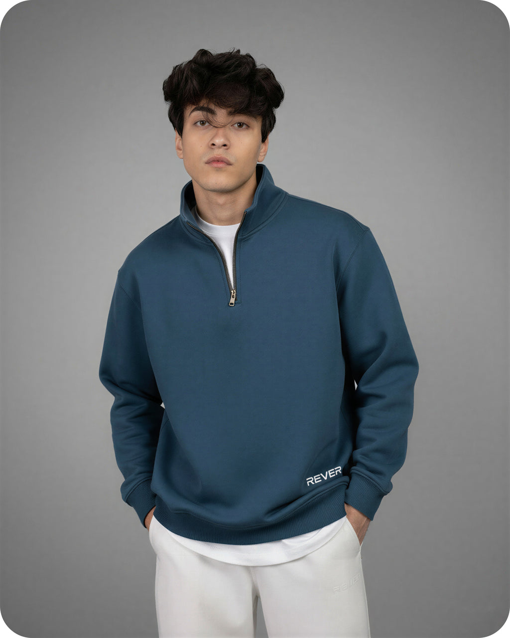 Person wearing a blue pullover with a zipper on a gray background