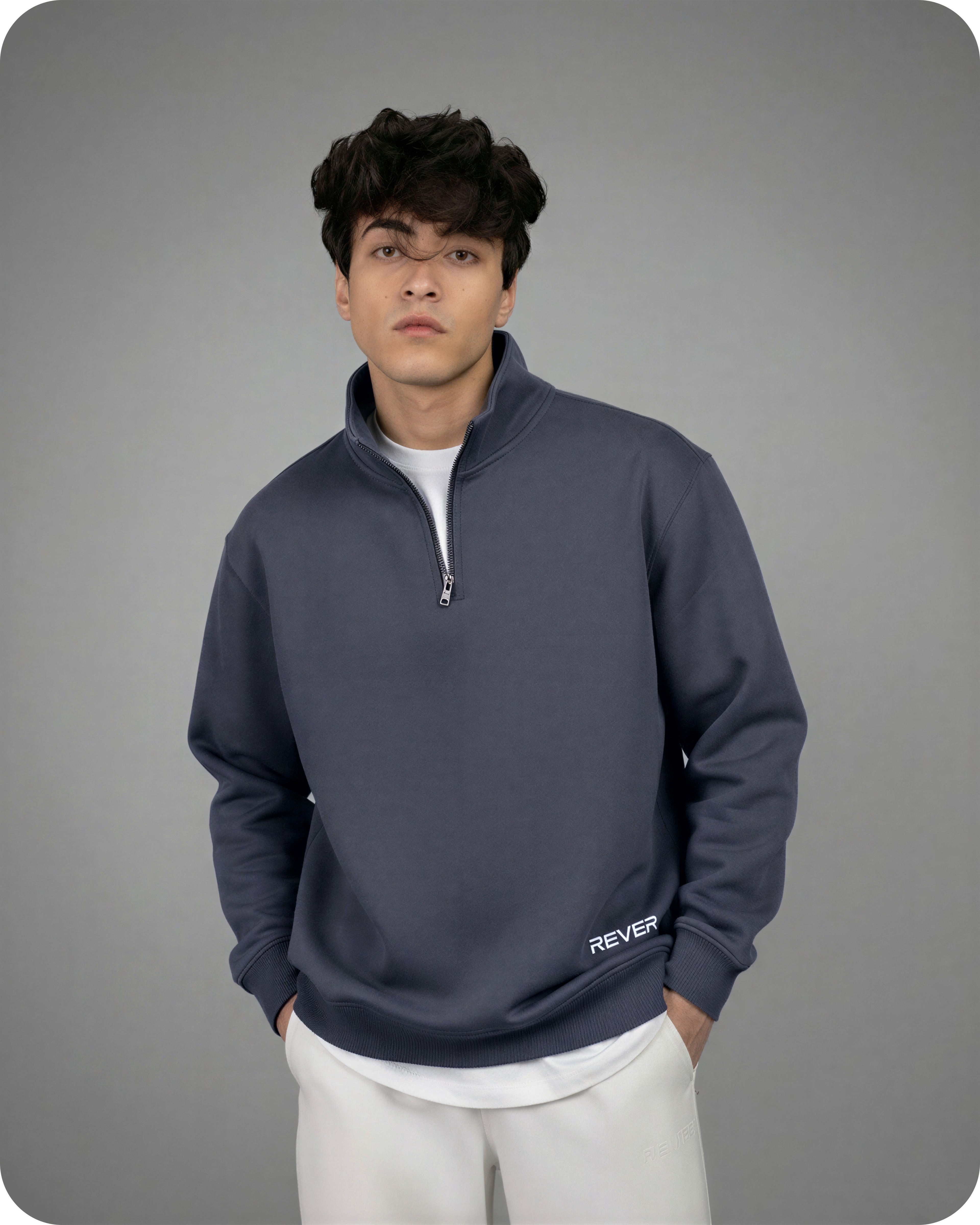 Person wearing a navy blue quarter-zip sweatshirt with 'Rever' branding on a gray background