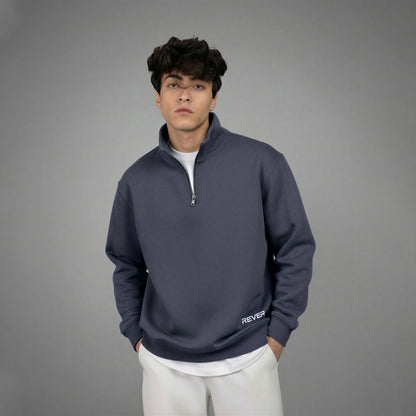 Person wearing a navy blue quarter-zip sweatshirt with 'Rever' branding on a gray background