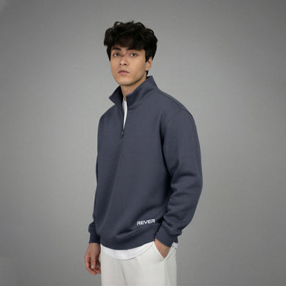 Man wearing a navy blue pullover with 'REVER' logo on a gray background