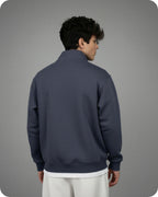 Person wearing a dark blue quarter-zip sweatshirt on a gray background