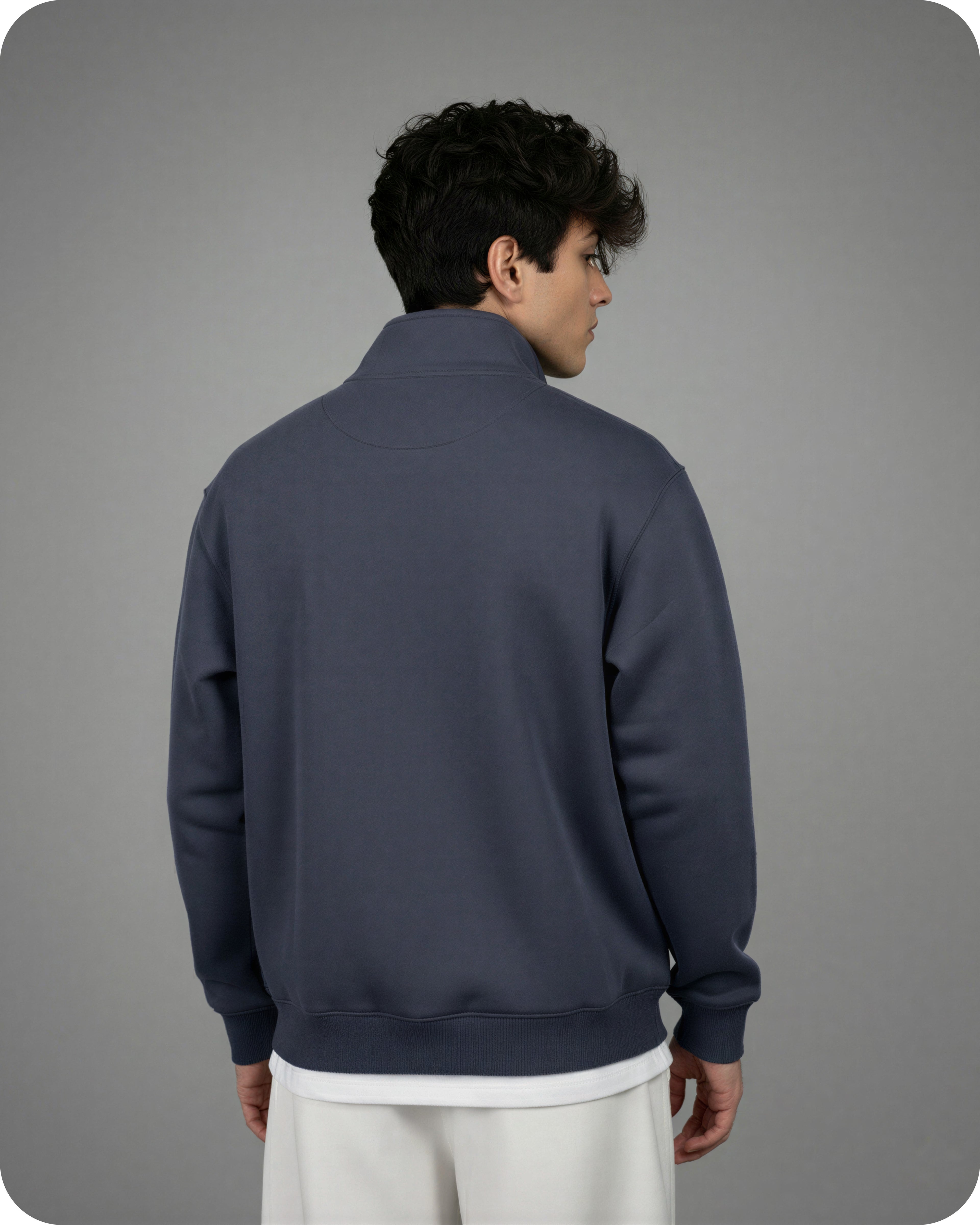 Person wearing a dark blue quarter-zip sweatshirt on a gray background
