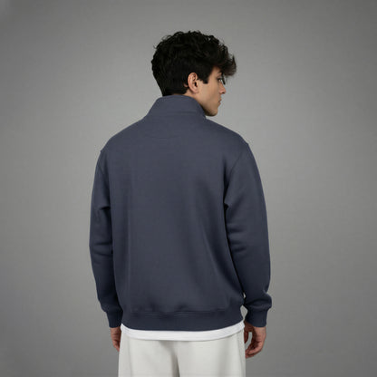 Person wearing a dark blue quarter-zip sweatshirt on a gray background