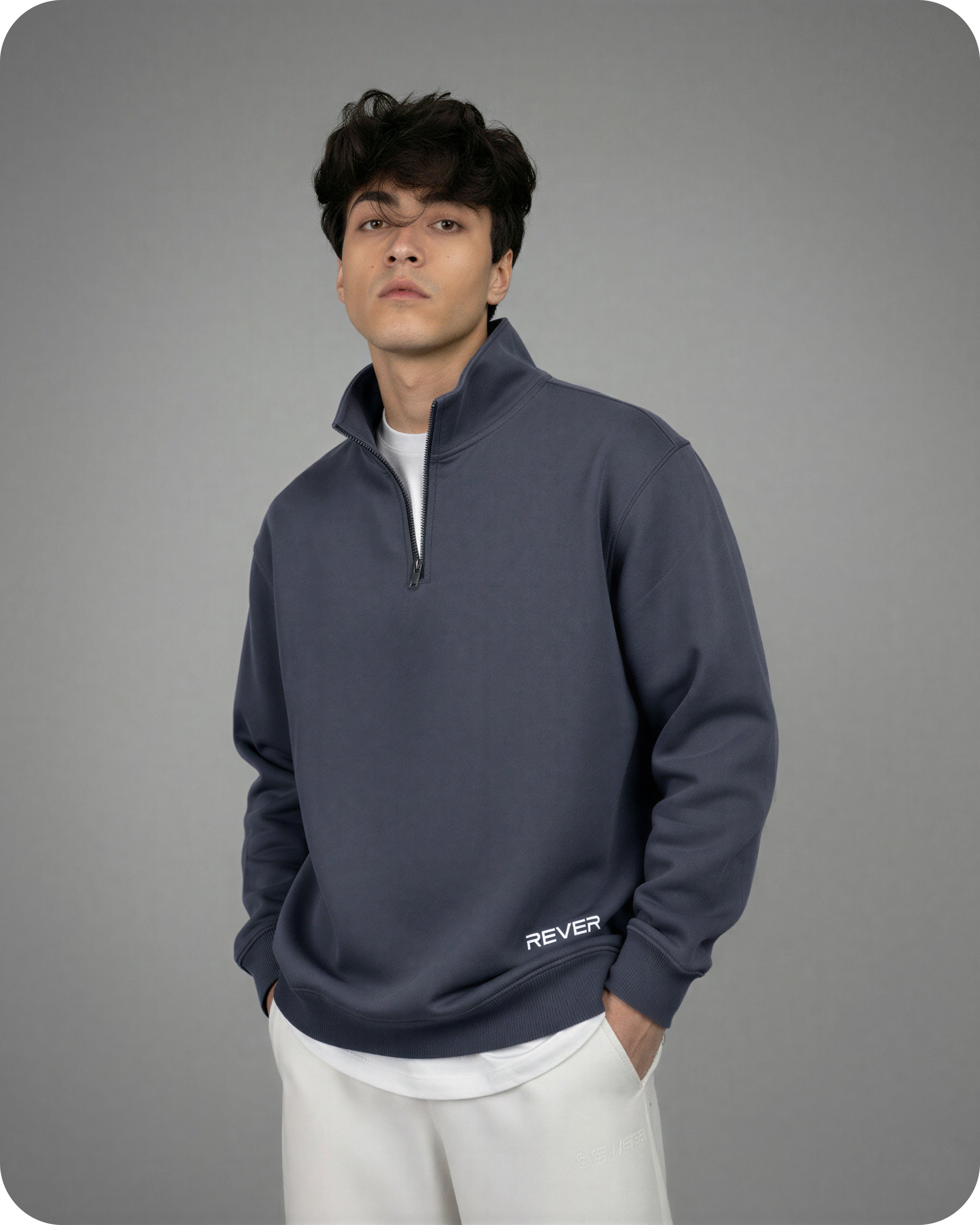 Man wearing a dark blue pullover with 'REVER' branding on a gray background