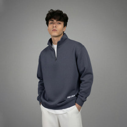 Man wearing a dark blue pullover with 'REVER' branding on a gray background