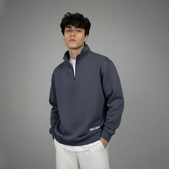 Man wearing a dark blue pullover with 'REVER' branding on a gray background