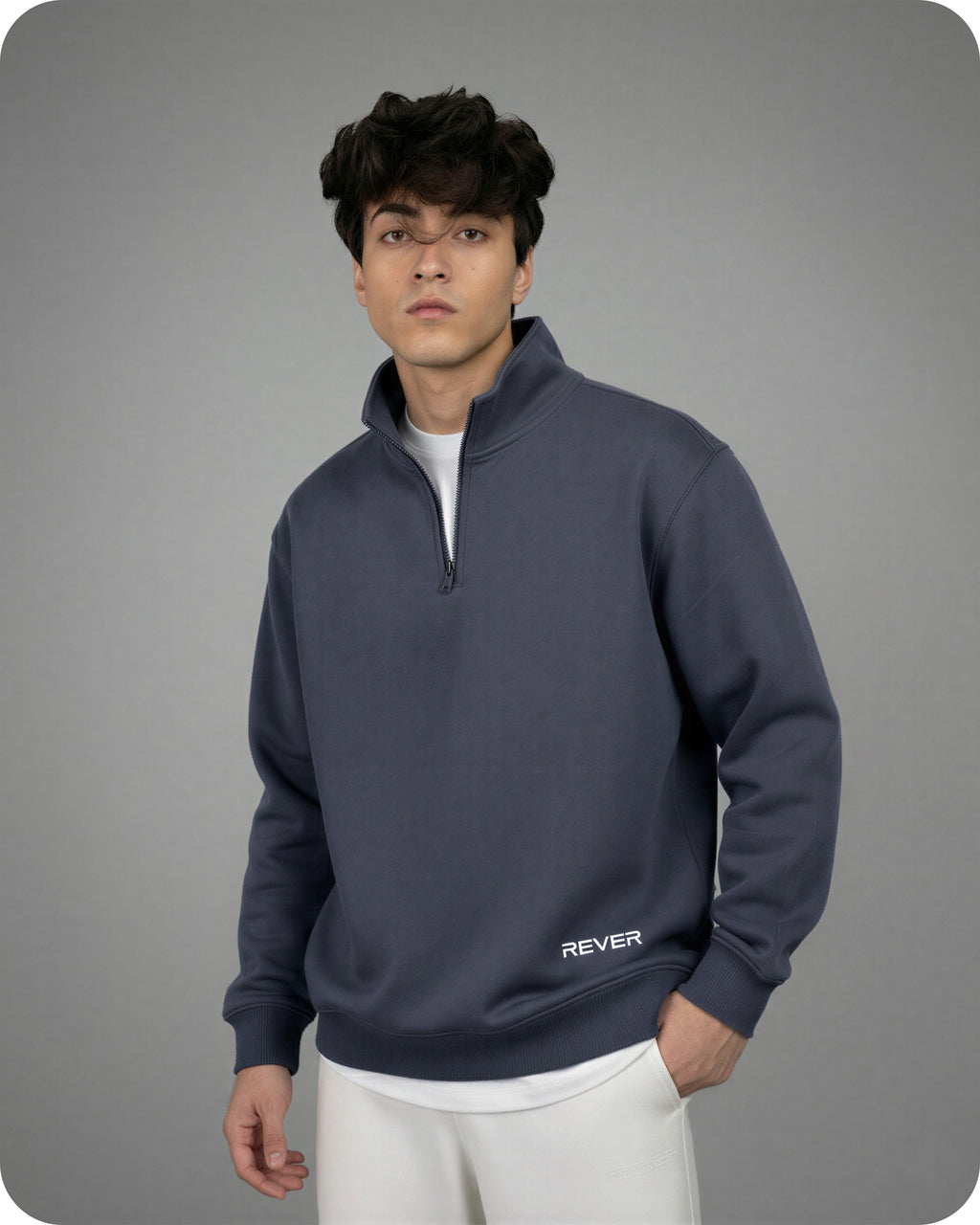 Man wearing a dark blue pullover with 'REVER' branding on a gray background