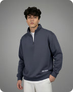 Man wearing a dark blue pullover with 'REVER' branding on a gray background