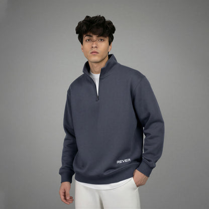Man wearing a dark blue pullover with 'REVER' branding on a gray background