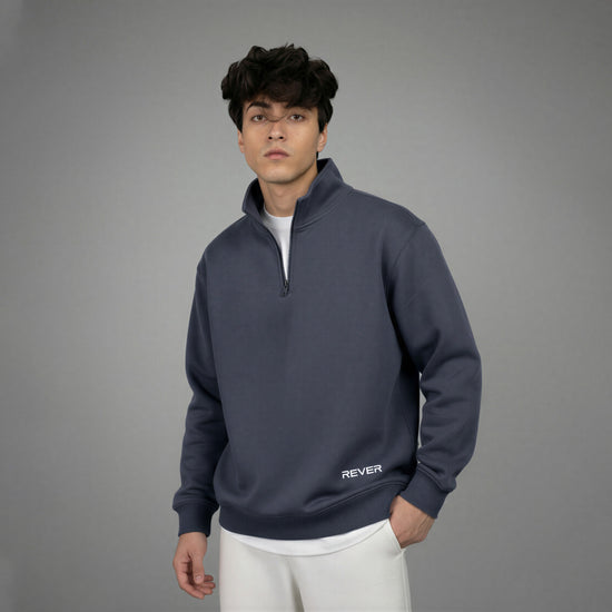 Man wearing a dark blue pullover with 'REVER' branding on a gray background