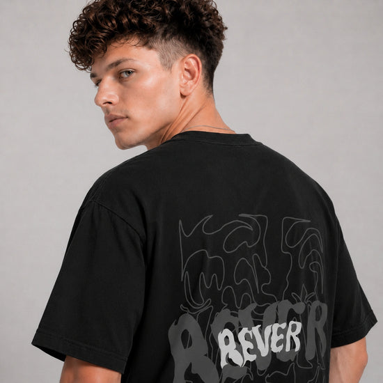 Person wearing a black t-shirt with 'REVER' printed on the back against a gray background
