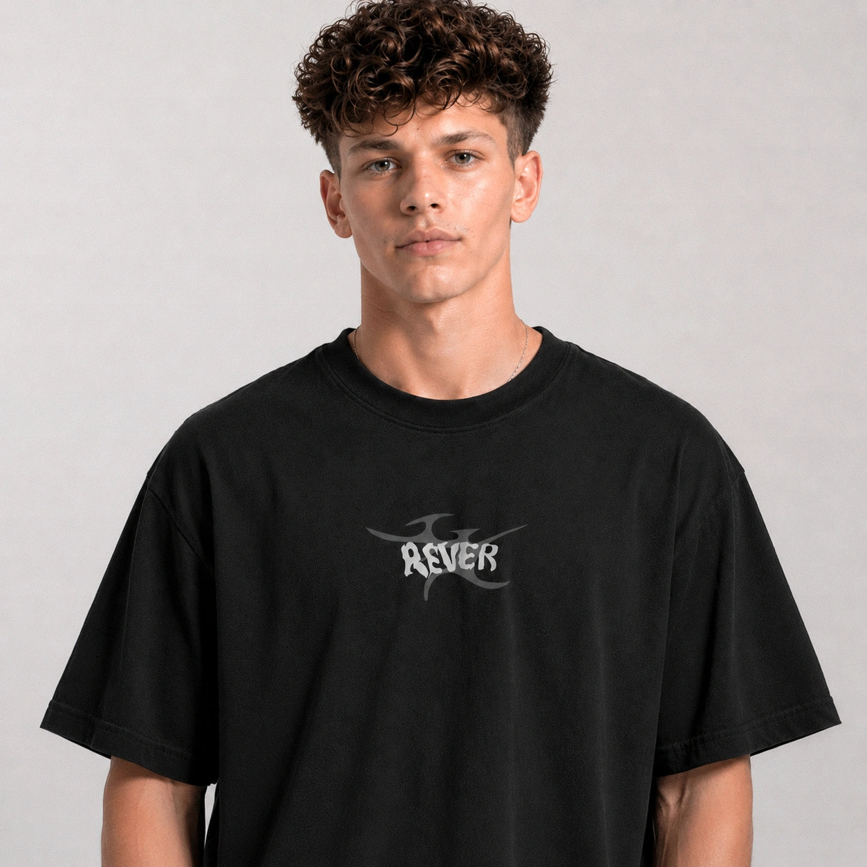 Person wearing a black t-shirt with a logo on a gray background