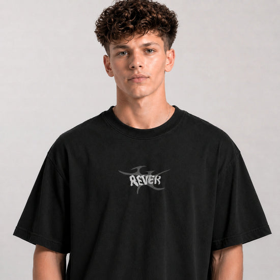 Person wearing a black t-shirt with a logo on a gray background