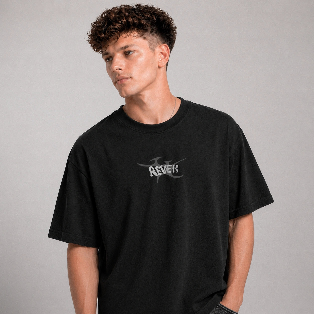 Person wearing a black t-shirt with a logo on a gray background