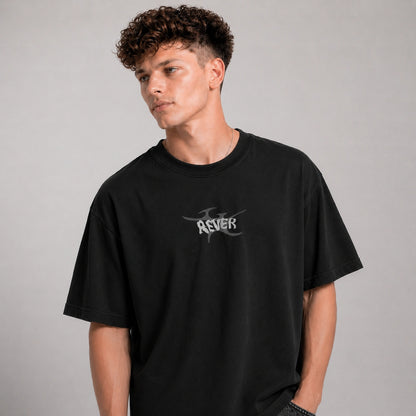 Person wearing a black t-shirt with a logo on a gray background