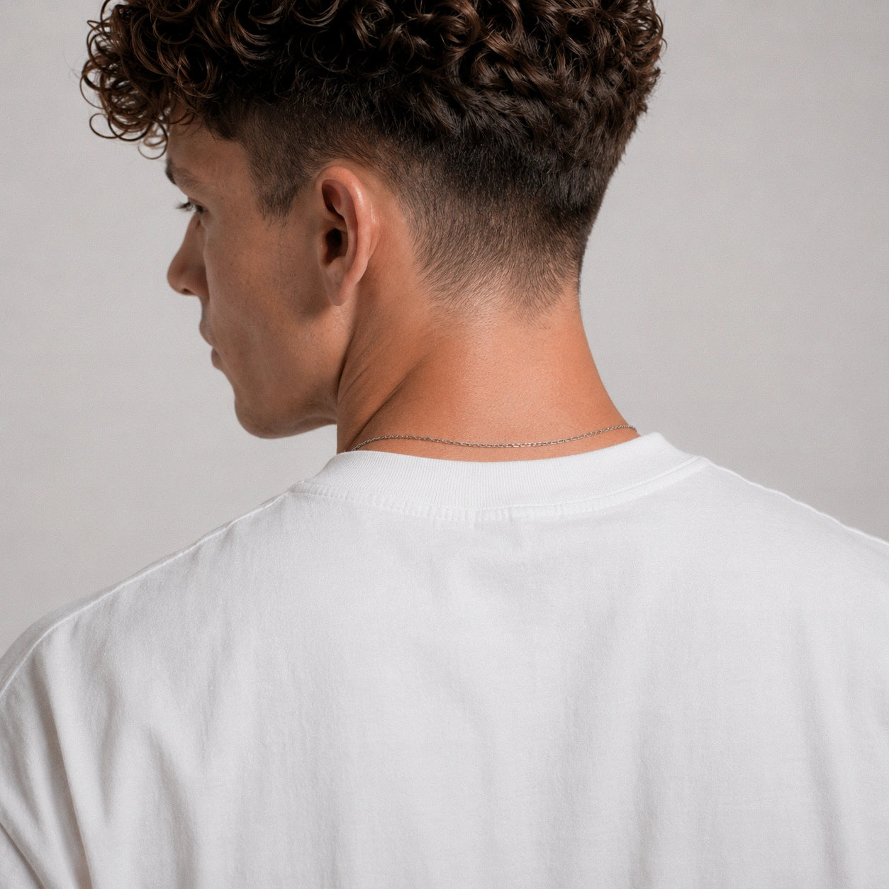 Person wearing a white shirt against a plain background