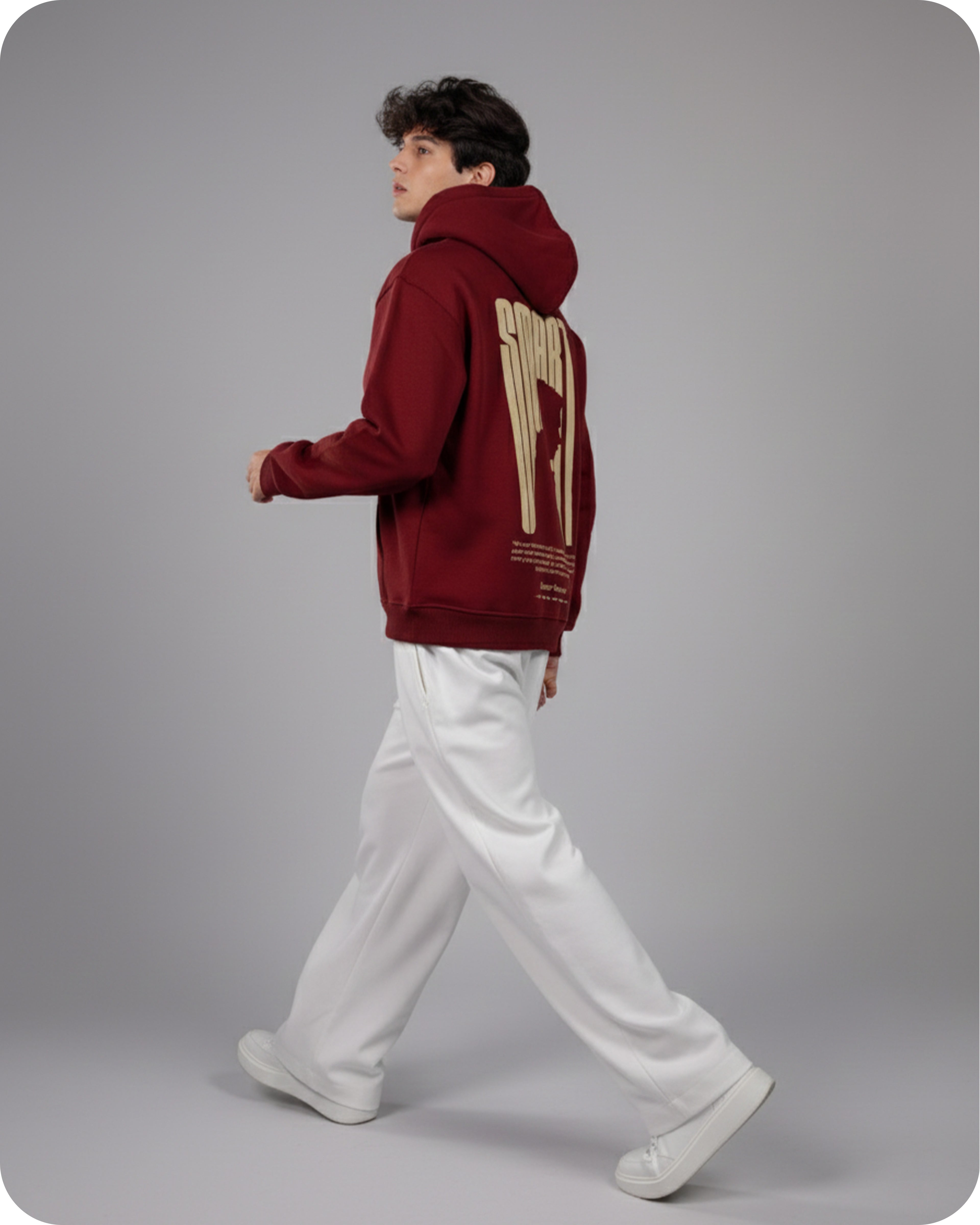 Person wearing a red hoodie with gold text on a gray background