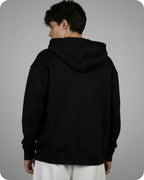 Person wearing a black hoodie from behind on a gray background